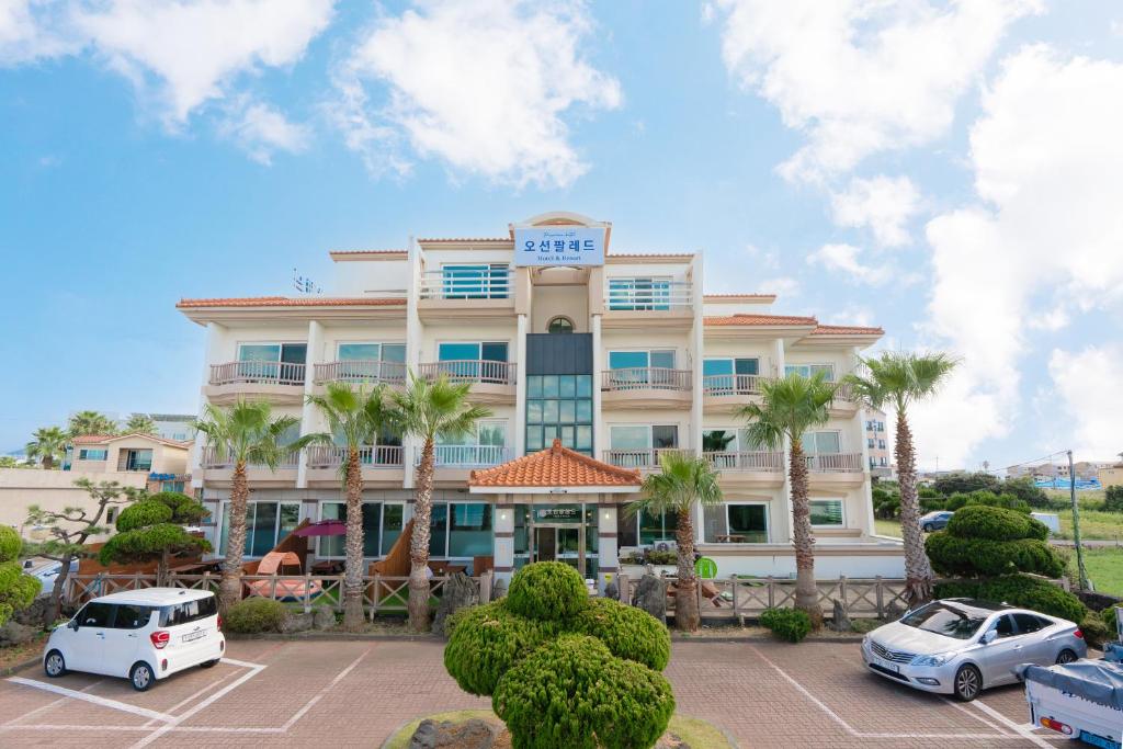 un hotel con coches aparcados delante en Ocean Palade Hotel en Jeju
