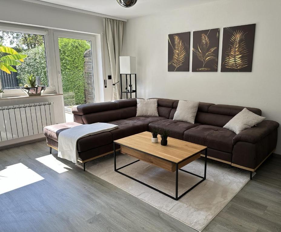 a living room with a brown couch and a coffee table at Nollywood-Apartment in Rheinfelden