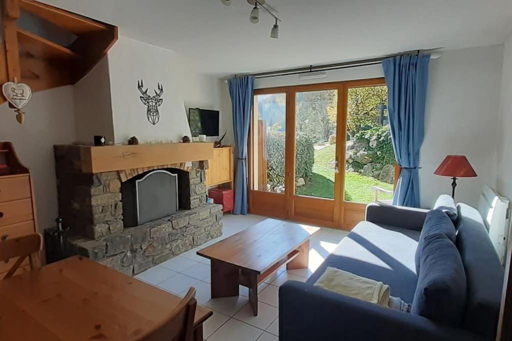 a living room with a blue couch and a fireplace at Joli triplex 3 étoiles, avec jardin et cheminée in Génos