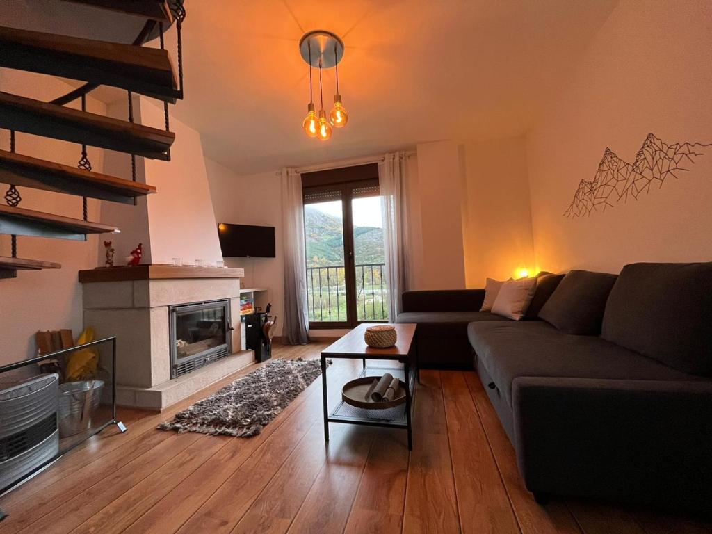 a living room with a couch and a fireplace at El refugio de Porma. in Puebla de Lillo