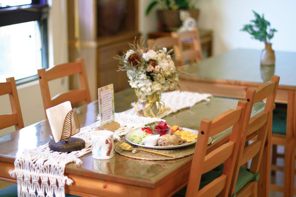 a dining room table with a plate of food on it at Pottery Flower B&B in Jiji