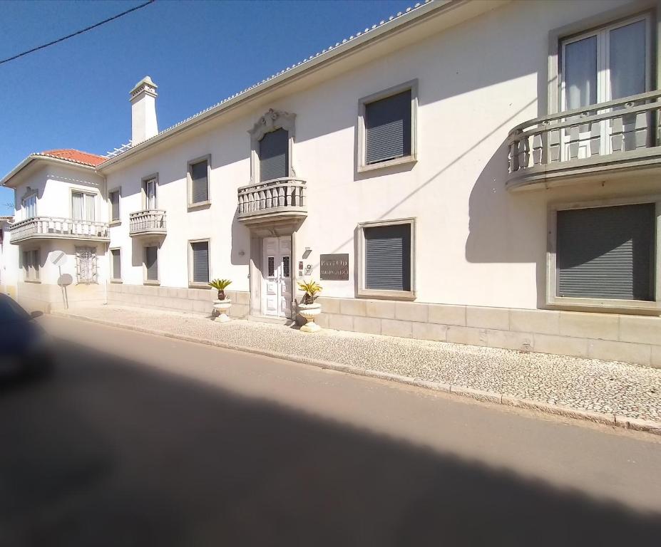 a white building with balconies on a street at Pateo do Morgado - Turismo de Habitacao in Casa Branca