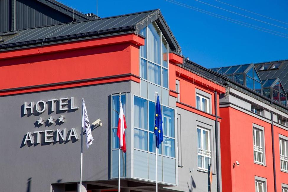 a hotel atenna building with flags in front of it at Hotel Atena Wedding, Business & Spa in Ciechanów