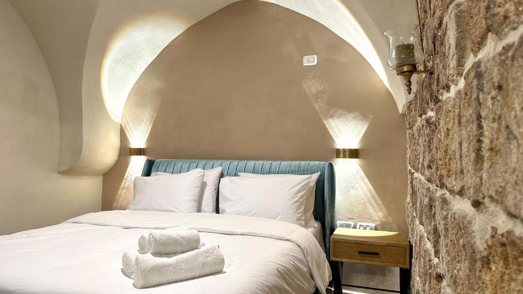 a bedroom with a bed with a stone wall at Knight house Akko in ‘Akko