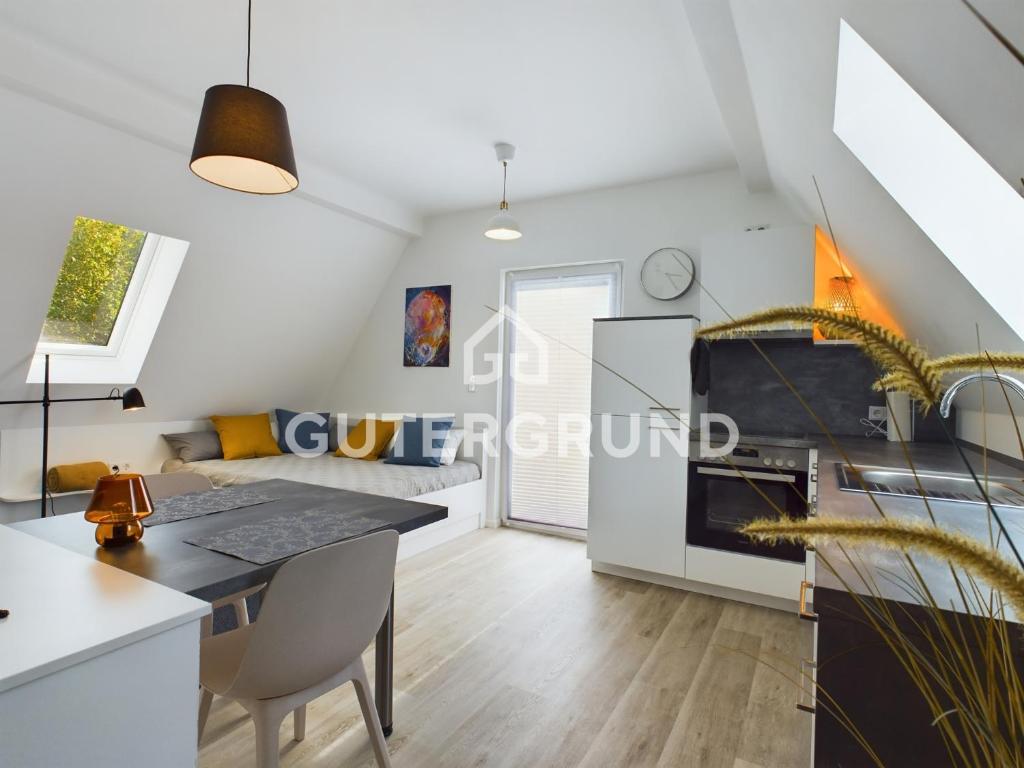 Studio-Apartment "Charlotte" في فسترشتيده: مطبخ وغرفة معيشة مع طاولة طعام وأريكة