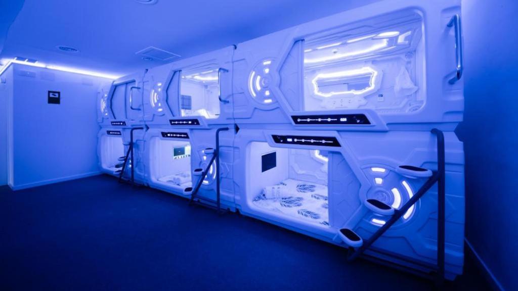 an empty room with blue lights in a room at GOOD VIBES ONLY Capsule Hostel Malaga in Málaga
