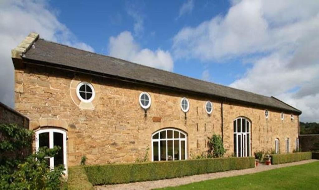 a brick building with four windows and a black roof at The Coach House, Wrexham Road in Wrexham