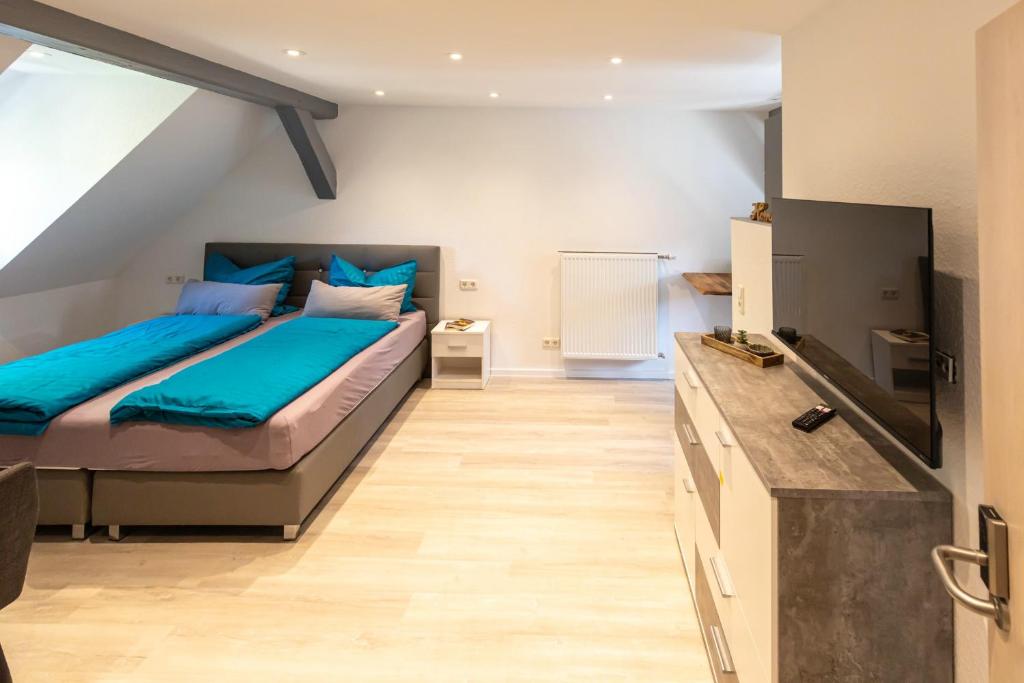 een slaapkamer met een bed en een flatscreen-tv bij Richter Altstadtappartements in Goslar