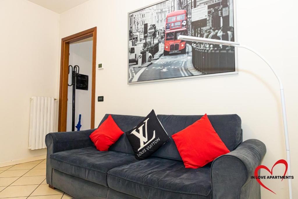 un sofá negro con almohadas rojas en la sala de estar. en In Love, en Montichiari