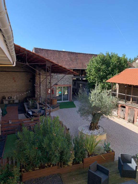 un jardin avec un arbre au milieu d'un bâtiment dans l'établissement Adorable Guest House « bienvenue chez vous ! », à Bordères-sur-lʼÉchez