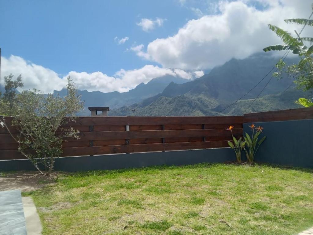 a wooden fence with mountains in the background at Le djebel in Cilaos