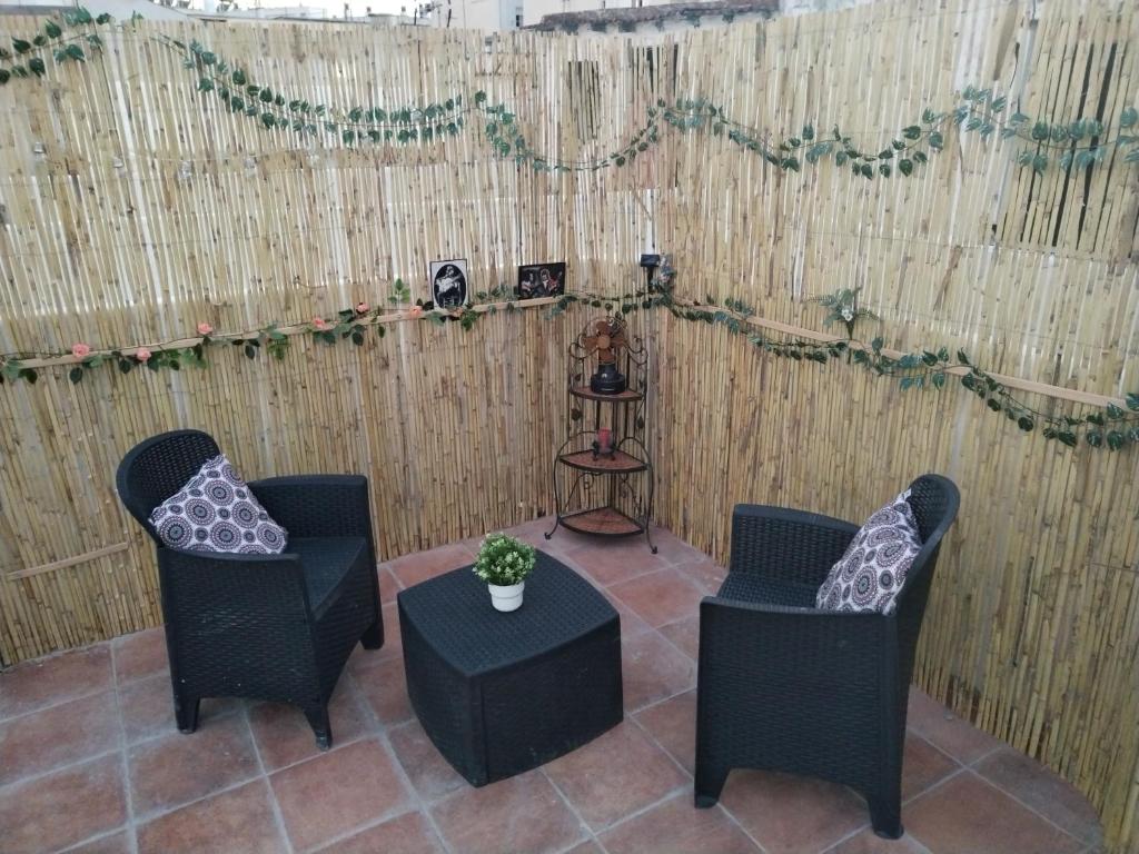 two chairs and a table in front of a fence at Apartamentos La Campana 5 in Jerez de la Frontera