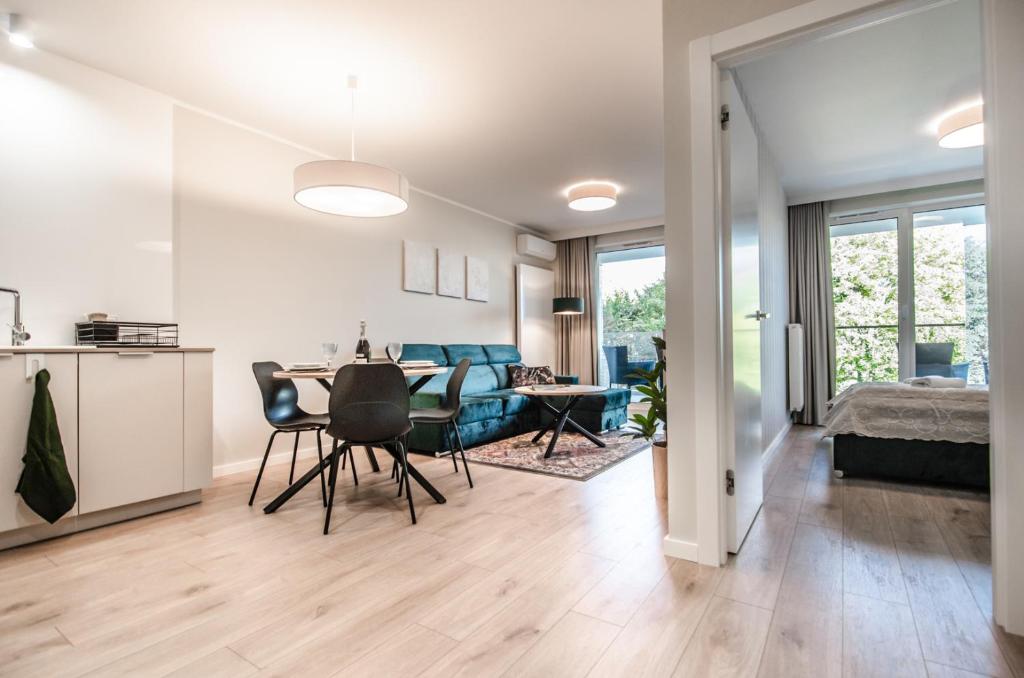 a living room and dining room with a table and chairs at Whiteblue apartamenty Kołobrzeg in Kołobrzeg