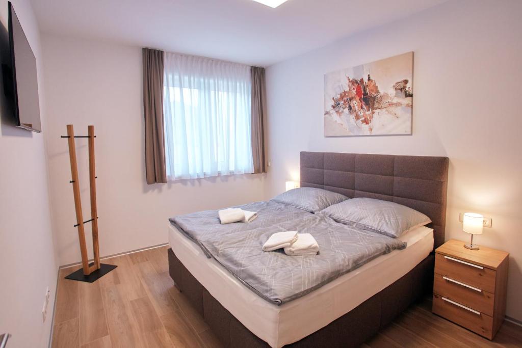 ein Schlafzimmer mit einem Bett mit zwei Handtüchern darauf in der Unterkunft Deluxe Apartment Leibnitz in Leibnitz