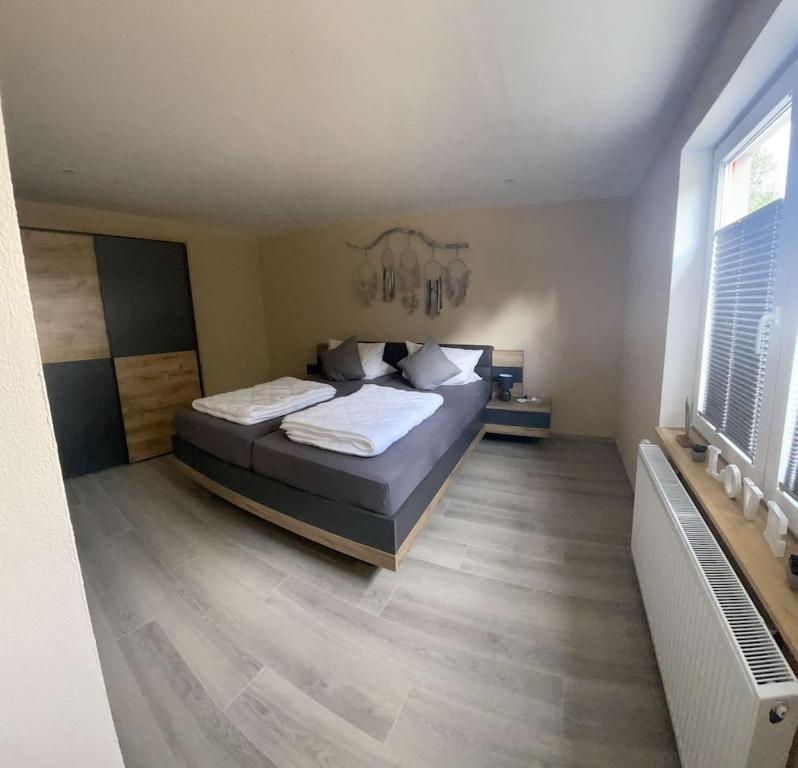 sypialnia z dużym łóżkiem z białymi poduszkami w obiekcie Pferdehof Simon w mieście Binscheid