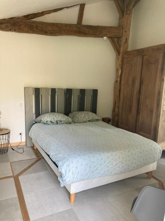 ein Schlafzimmer mit einem großen Bett in einem Zimmer in der Unterkunft Le Cysphée chez Christelle in Sallertaine