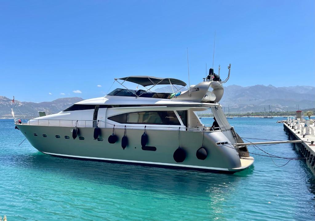 a white boat docked at a dock in the water at MotorYacht 21 avec équipage in Barcelona