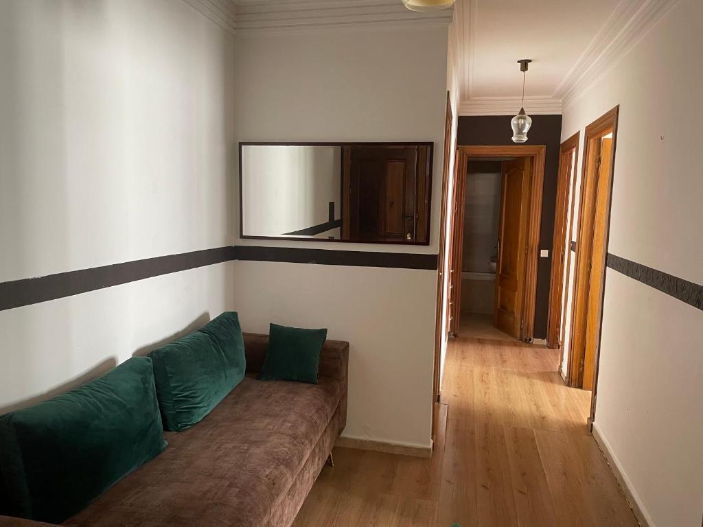 un salon avec un canapé et un miroir dans l'établissement Charmant appart 2 chamb+salon au cœur de la ville!, à Rabat