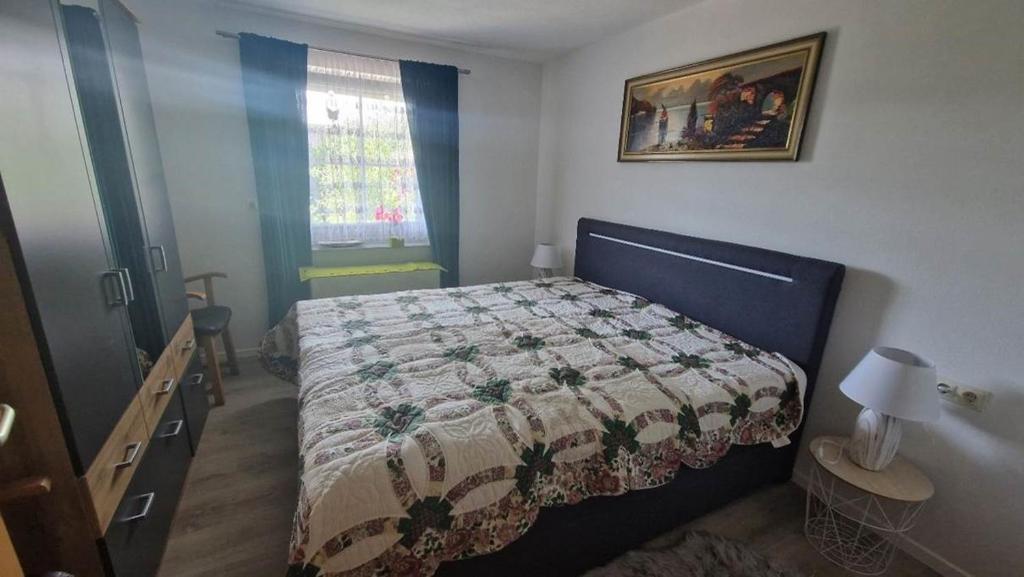 ein Schlafzimmer mit einem Bett mit einer Decke darauf in der Unterkunft FeWo Schellenbergstraße in Kißlegg