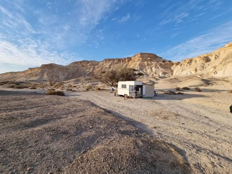 Una caravana en el desierto con montañas al fondo en ג'וני- חוויה בקארוון מדברי, en Sappir