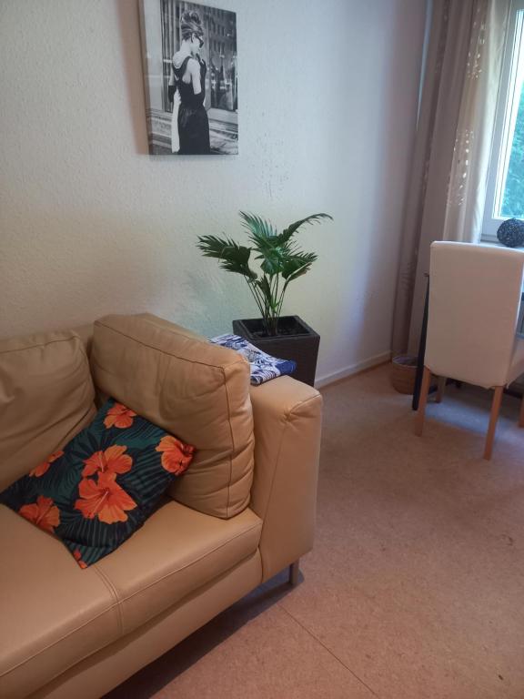 美茵河畔法蘭克福的住宿－Privates Zimmer，带沙发和盆栽植物的客厅