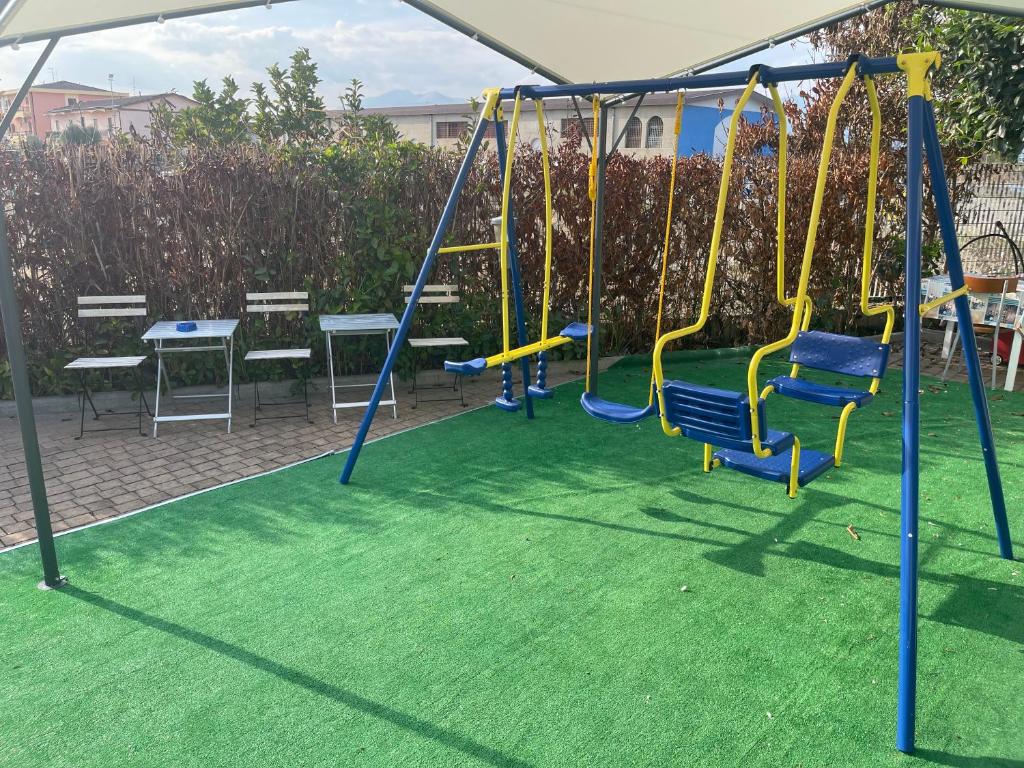 a playground with blue and yellow swings at B&B Villa Anna in Sibari