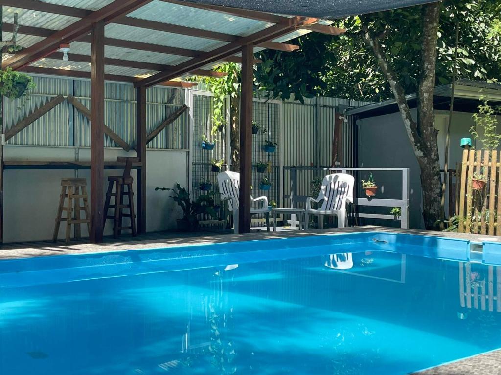 einen Pool mit einer hölzernen Pergola und einem Pool in der Unterkunft The Twin Studio Cottages 