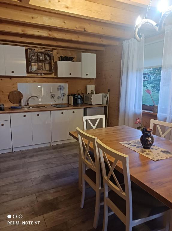 a kitchen with a wooden table and a table and chairs at Drewniany Domek in Bukowiec