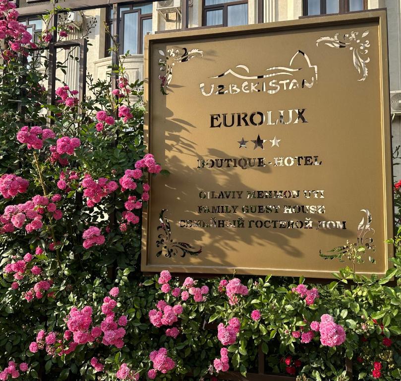 a sign with pink flowers in front of a building at Eurolux Boutique-Hotel in Tashkent