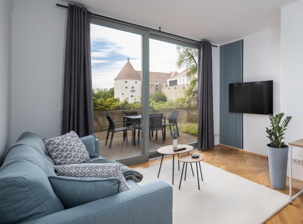 sala de estar con sofá azul y TV en CoView - Bautzen - Design Apartment in der Altstadt mit fantastischem Ausblick en Bautzen