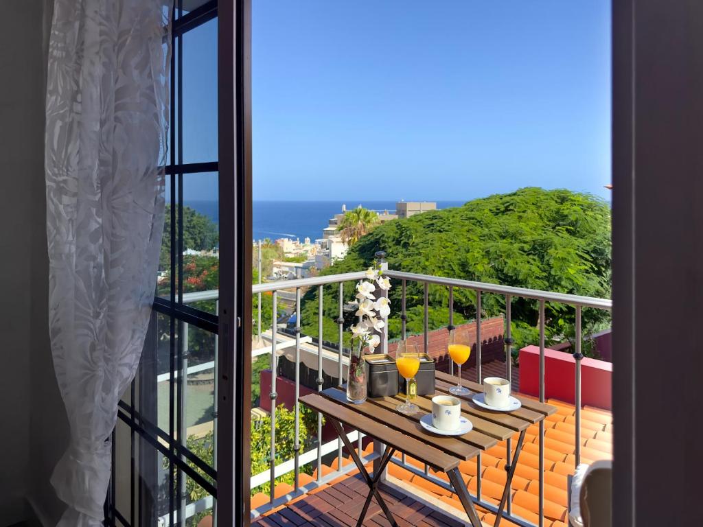 Un balcón con una mesa con dos vasos. en Las Vistas-Rincón acogedor con vistas al mar en Tabaiba