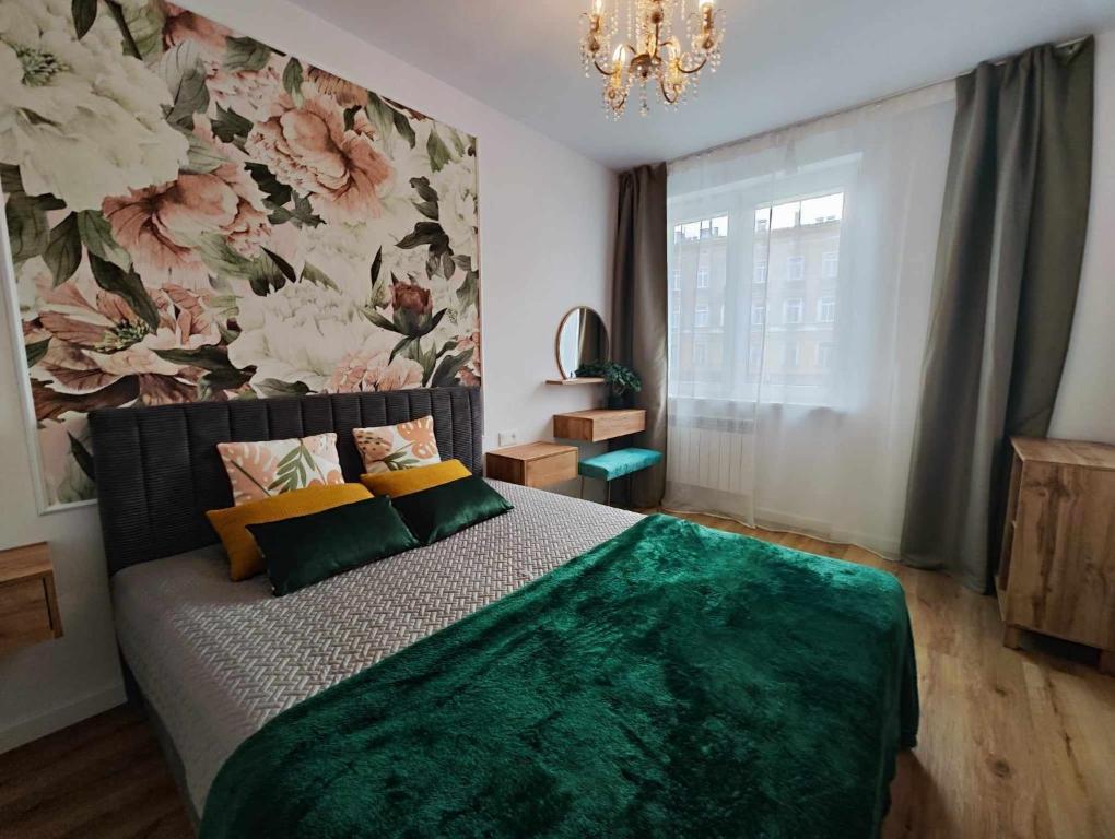 1 dormitorio con 1 cama con pared de flores en Centrum Miasta en Stargard Szczeciński