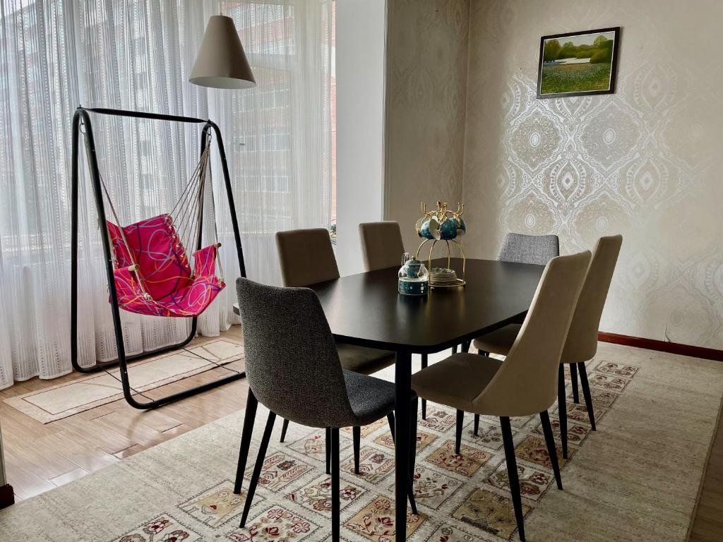 - une table à manger noire avec des chaises et un sac rose dans l'établissement Spacious 140m2, 2 bedrooms apartment, à Oulan-Bator