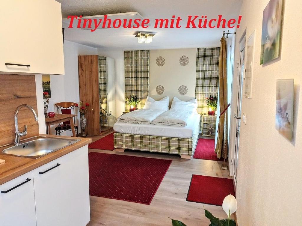 uma pequena cozinha com uma cama numa pequena casa em Tinyhouses am Neusiedlersee em Fertőrákos