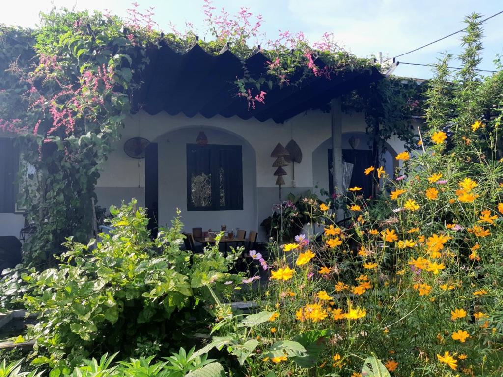 einen Garten vor einem Haus mit Blumen in der Unterkunft Vom Vom Garden House in Đà Nẵng