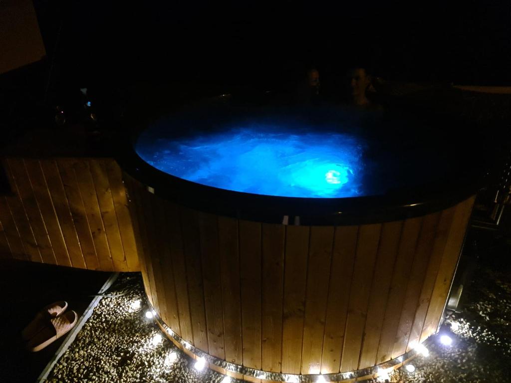 una bañera de hidromasaje por la noche con luces. en Apartament Danuta Mrągowo, en Mrągowo