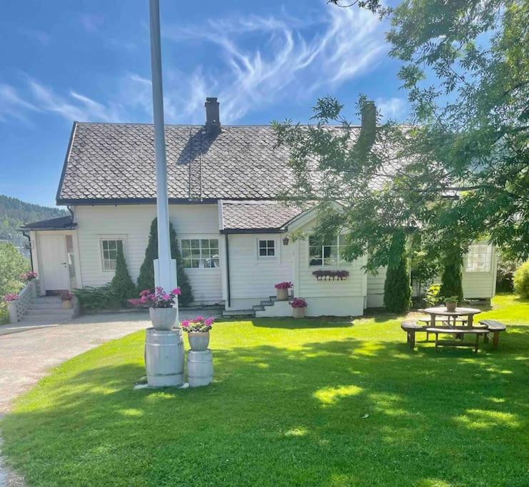 ein weißes Haus mit einem Picknicktisch im Hof in der Unterkunft Nakkentunet - familievennlig hus på gårdstun. in Ørskog
