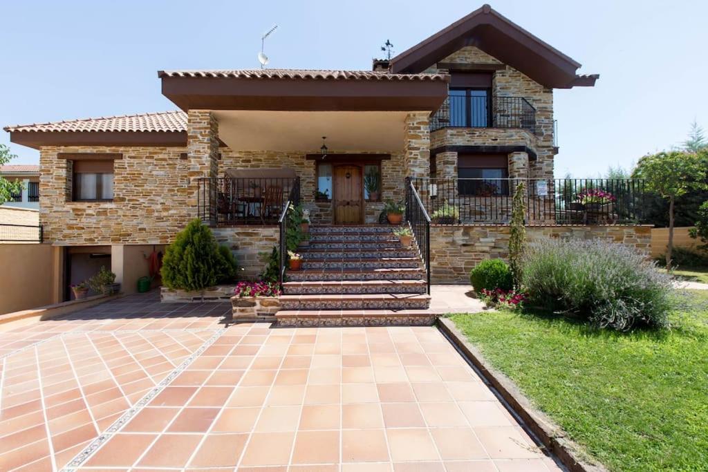 een huis met een stenen huis met een trap en een veranda bij Los Rosales de Venturada in Venturada
