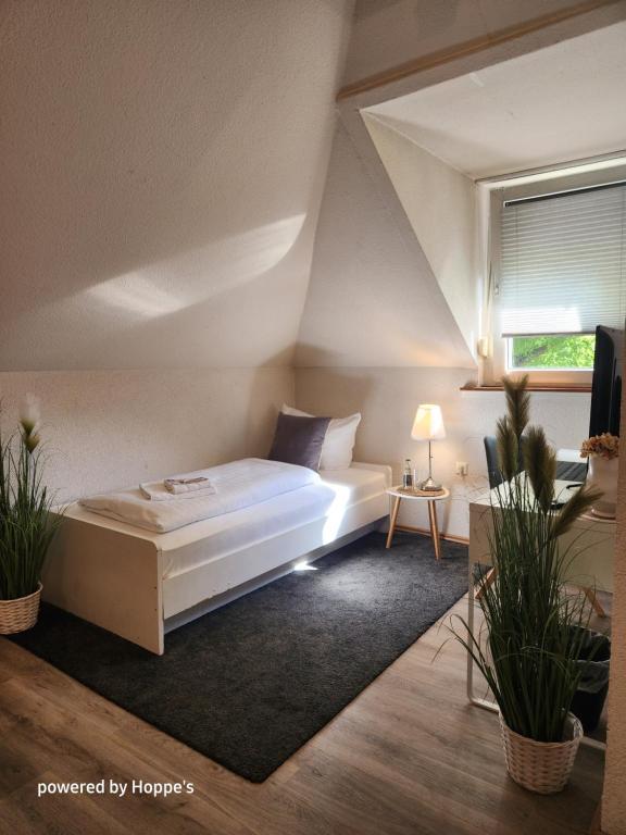 1 dormitorio con 1 cama blanca en el ático en Hotel Hoppe, en Witten