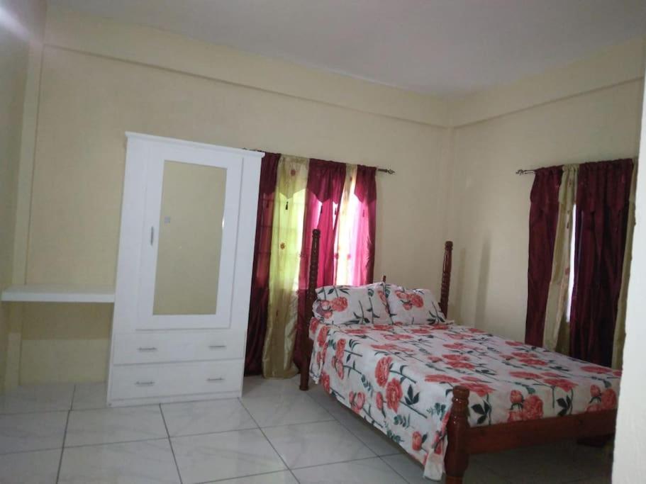 a bedroom with a bed and a dresser and a mirror at Ark Royal of the Caribbean in Kingstown