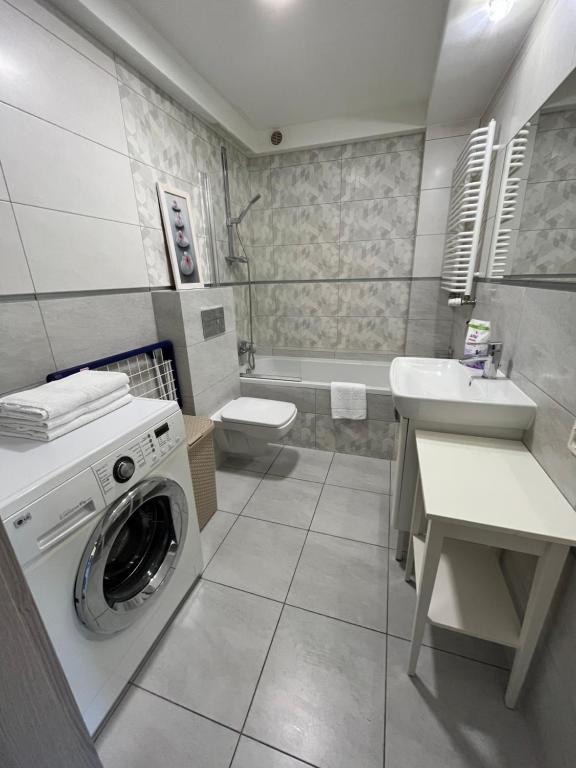 a bathroom with a washing machine and a sink at Apartament COMFORT Centrum in Krotoszyn