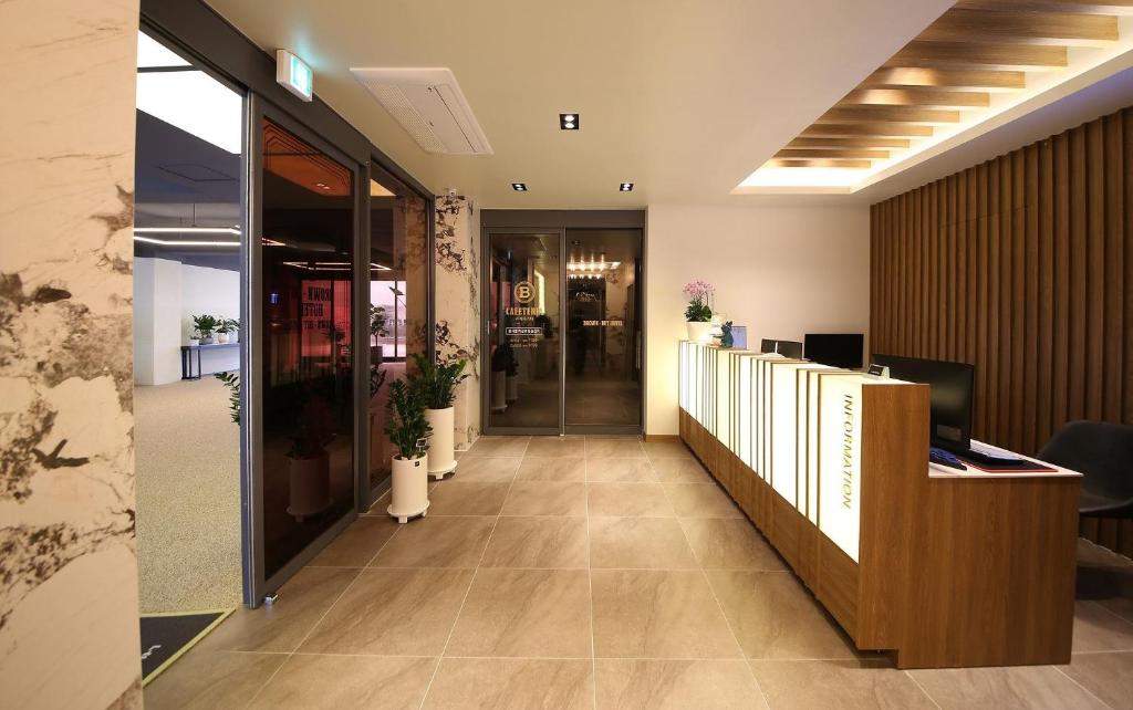 an office lobby with a reception desk and a hallway at Brown Dot Hotel Sinan in Gwangju