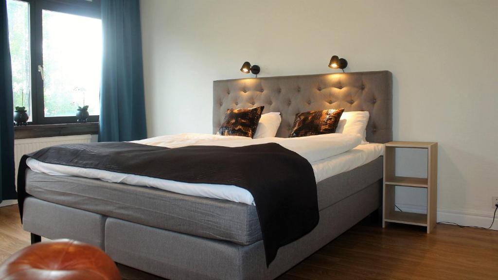 a bedroom with a large bed with a headboard at Millners Plaza in Tibro