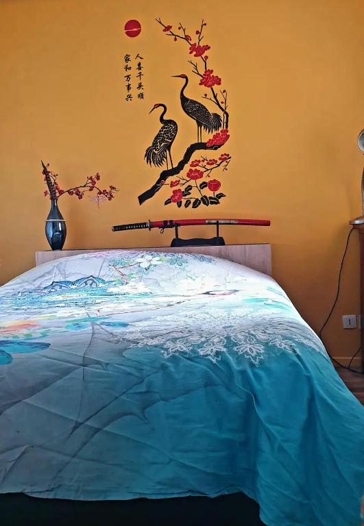 chambre sur Muret في موريه: غرفة نوم مع سرير والطيور على الحائط