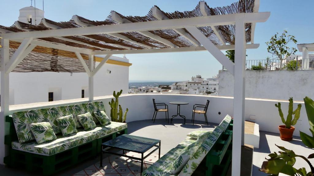 een patio met een bank en stoelen op een dak bij Casa Bonhomía in Vejer de la Frontera