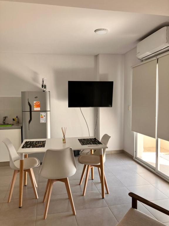 une salle à manger avec une table et des chaises blanches dans l'établissement Departamento D, à Bahía Blanca