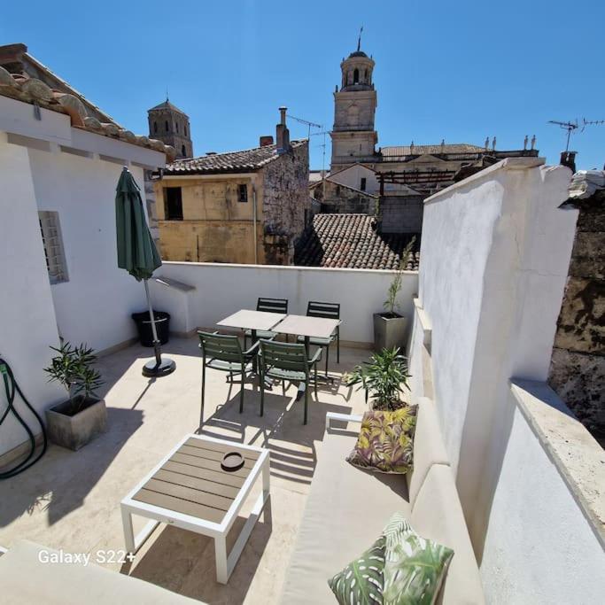un patio avec tables et chaises sur un balcon dans l'établissement The Rooftop Arles - Terrasse panoramique, à Arles