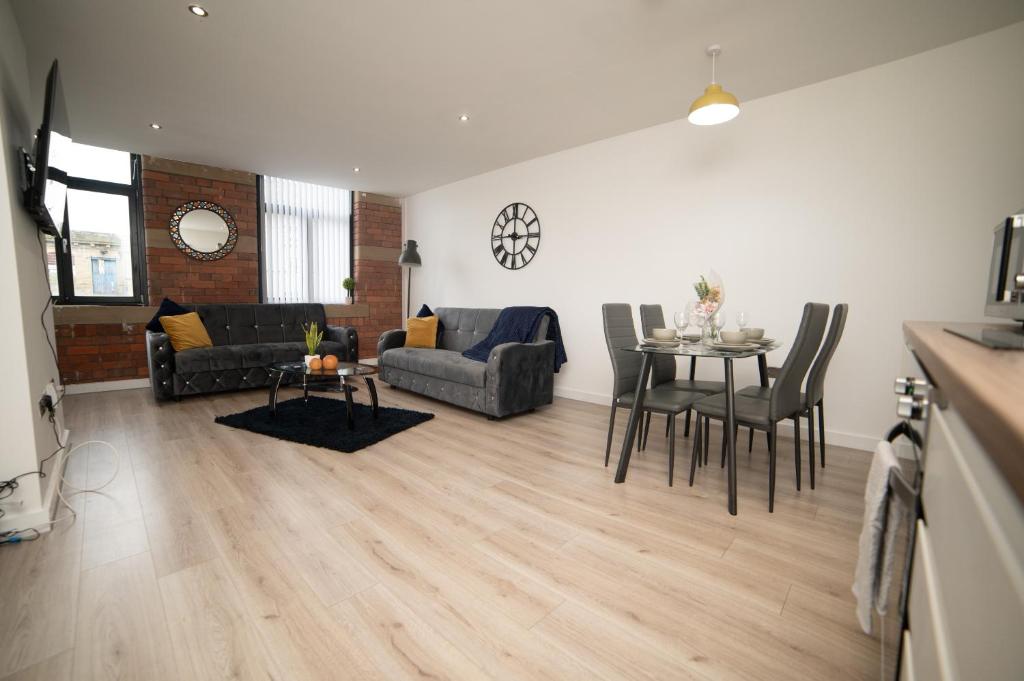 sala de estar con sofá y mesa con sillas en Bv Luxury Apartment Conditioning House en Bradford