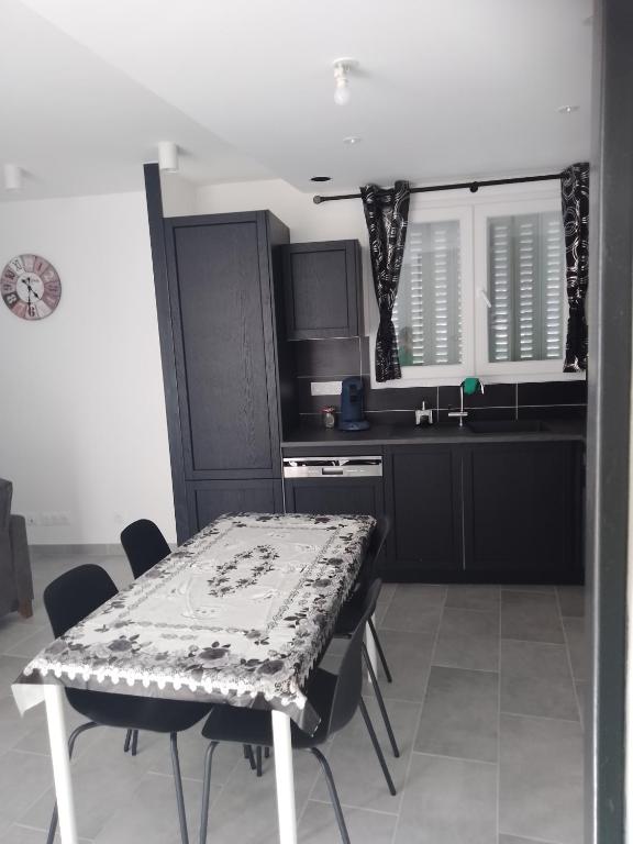 - une cuisine avec une table, des chaises et un comptoir dans l'établissement appartement T2 neuf et design, à Pérignat-lès-Sarliève