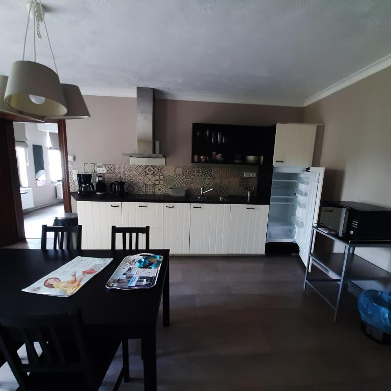 uma cozinha com uma mesa e uma sala de jantar em Huize tinke em Tongeren